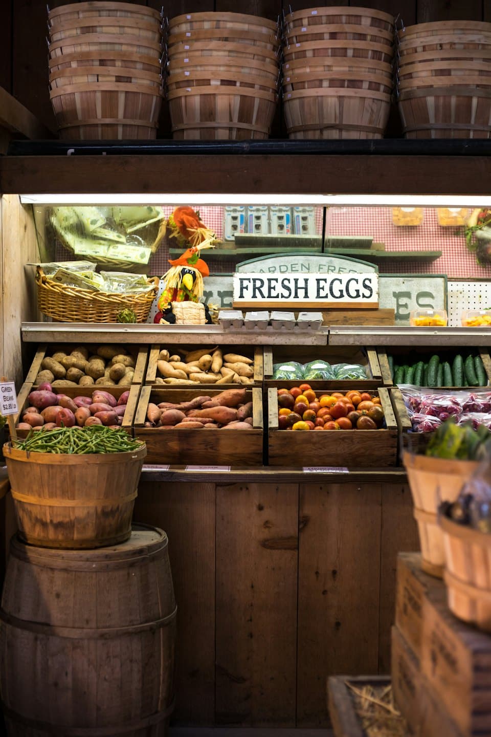 Fresh produce including tomatoes and potatoes in wooden crates.